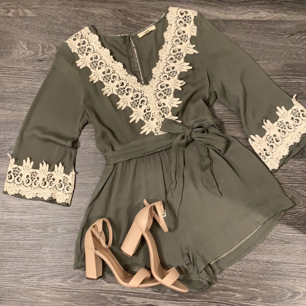 Olive romper with cream crochet accents and waist tie bow